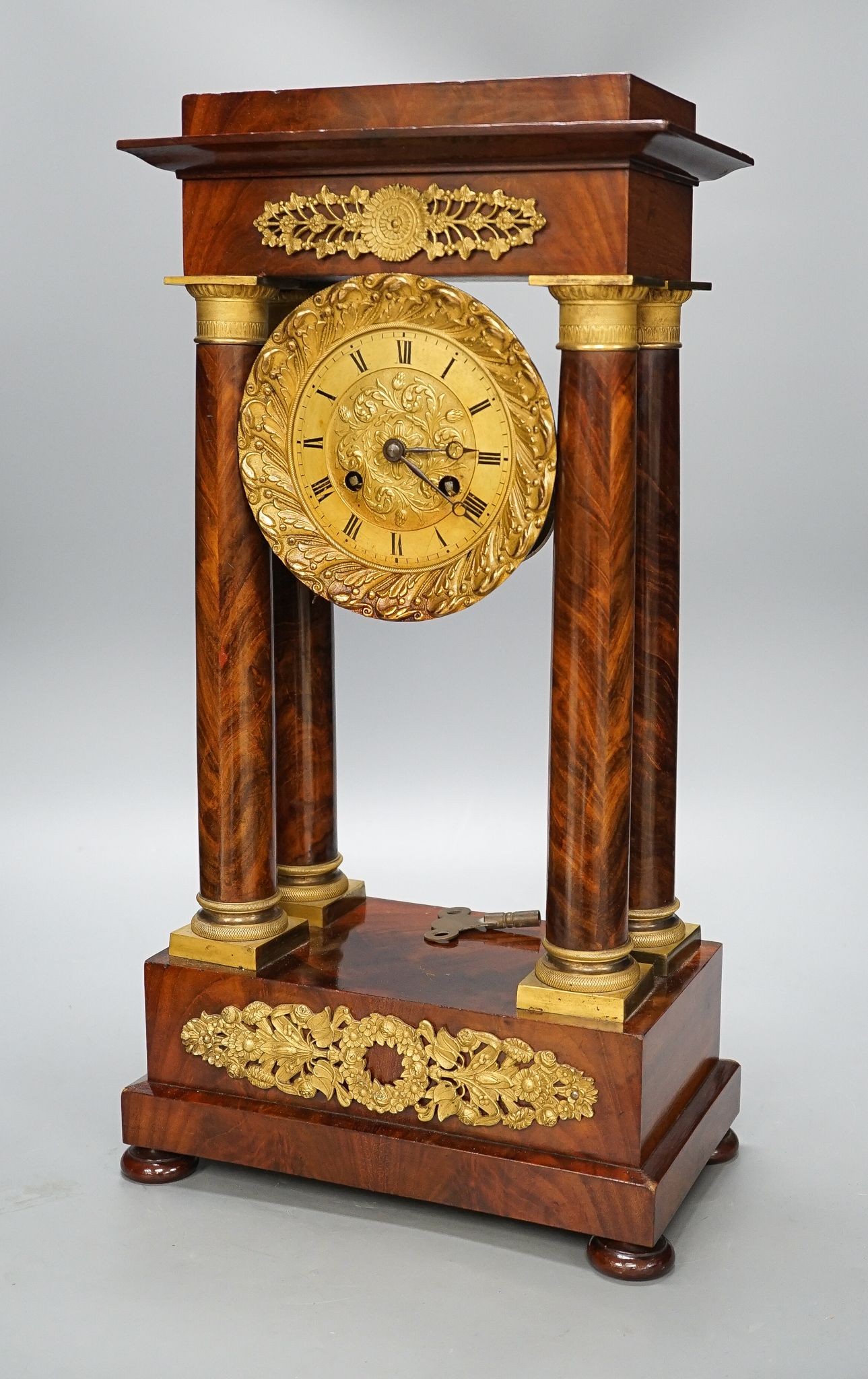 An early 19th century mahogany portico clock with three keys and spare bell, 50cm